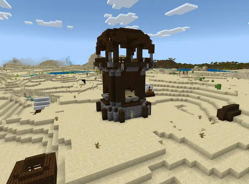 Pillager outpost tower in a Minecraft desert biome with pillagers and a white banner